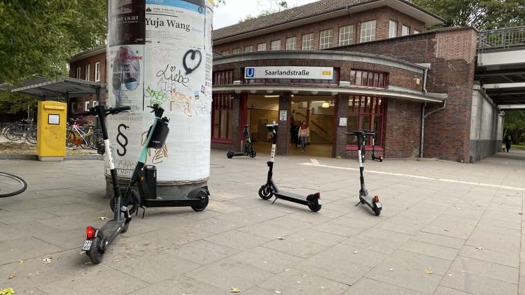 E-Scooter stehen verteilt vor dem U-Bahnhof Saarlandstraße.
