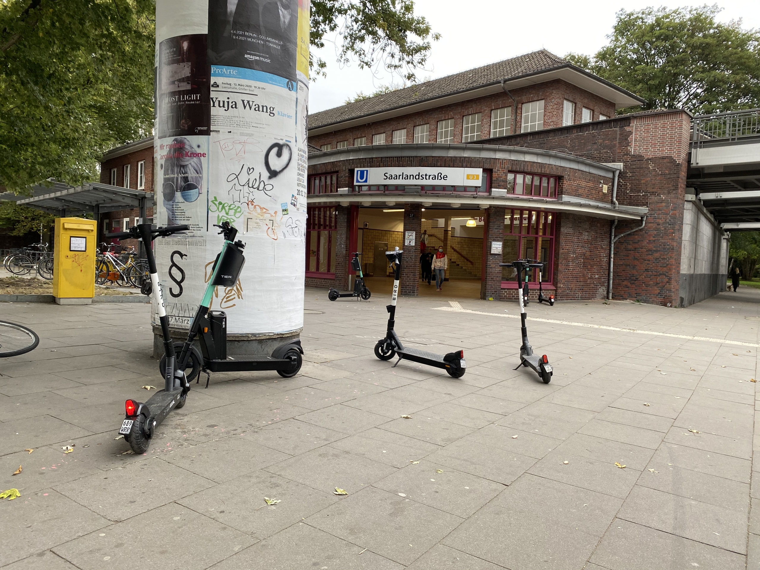 E-Scooter stehen verteilt vor dem U-Bahnhof Saarlandstraße.